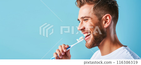 Portrait of a young man in profile who brushes his teeth with a manual toothbrush, blue background copy space. Concept of dental care and health, oral hygiene, prevention of dental diseases 116386319