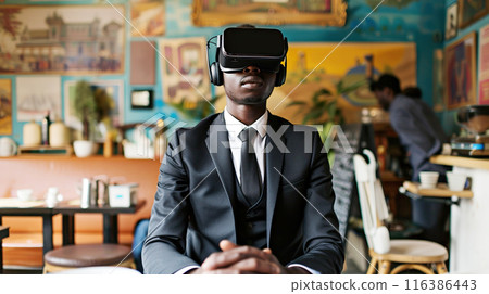 Businessman wearing virtual reality headset testing VR technology. A dark-skinned young confident man in business suit sits in cafe wearing VR reality glasses Businessman wearing virtual reality headset testing VR technology. A dark-skinned young confident man in business suit sits in cafe wearing VR reality glasses 116386443