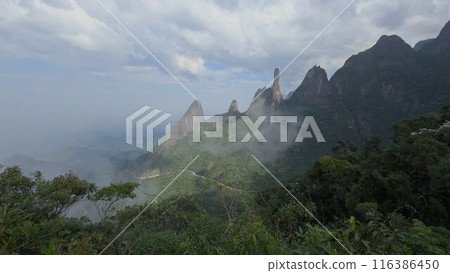 Dramatic Rocky Peaks Surrounded by Lush Jungle and Clouds 116386450