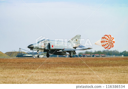 An Air Self-Defense Force F-4EJ Kai fighter jet landing with its drag chute extended 116386534