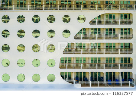 Large cruise ship side view fragment with round portholes rows and balconies with railing 116387577
