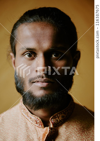 Portrait of handsome and confident Indian man with nose ring staring at camera Portrait of handsome and confident Indian man with nose ring staring at camera 116387675