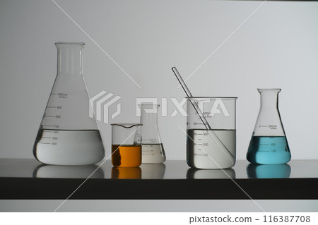 The photography of front angle in laboratory scene, variety types of experiment glassware containing liquid including glass beaker, erlenmeyer and boiling flask. Blank space for advertising 116387708