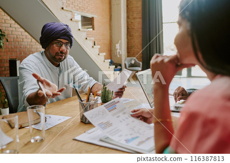 Indian teamlead and employees having heated discussion while having offline meeting in comfortable modern office Indian teamlead and employees having heated discussion while having offline meeting in comfortable modern office 116387813