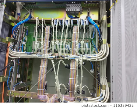 Telephony cables and wires connected to connectors and motherboards fixed on slats and secured with nylon white clamps 116389422