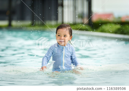 happy toddler baby playing water splashing in swimming pool 116389506