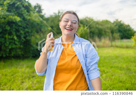 Woman applying insect repellent against mosquito, summertime health care, protection and people concept Woman applying insect repellent against mosquito, summertime health care, protection and people concept 116390846