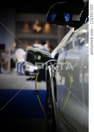 Power cable pump plug in charging power to electric vehicle EV car. 116391305