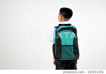 Back view Asian little boy primary posing with black and green backpack studio isolated white background, happy cute man kid wear school uniform and schoolbag, back to school concept 116391306