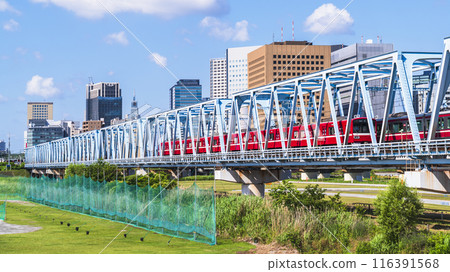 川崎的城市景觀：穿越多摩川的京急線列車和川崎站前的建築物[神奈川縣川崎市] 116391568