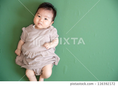 Baby lying down on green screen background 116392172
