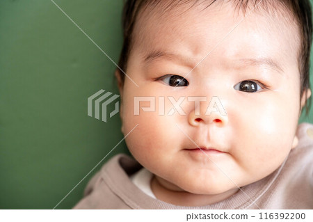 Baby lying down on green screen background Baby lying down on green screen background 116392200