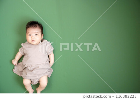 Baby lying down on green screen background Baby lying down on green screen background 116392225