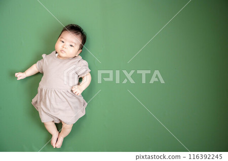 Baby lying down on green screen background Baby lying down on green screen background 116392245