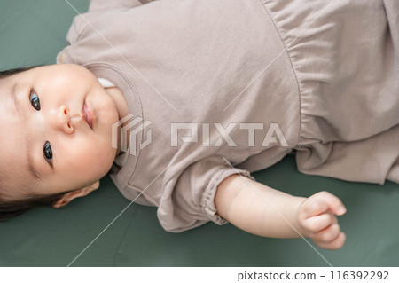 Baby lying down on green screen background Baby lying down on green screen background 116392292