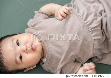 Baby lying down on green screen background 116392295
