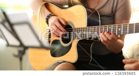 Female hands holding and playing western 116393685