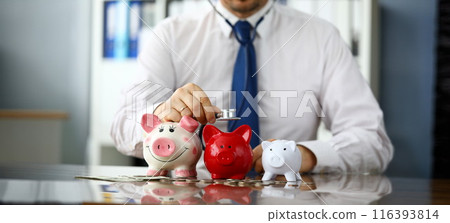 Funny businessman listen three piggybanks for cash 116393814