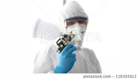 Workman hold in arm airbrush gun wearing protective suit Workman hold in arm airbrush gun wearing protective suit 116393821