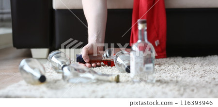The hand of an alcoholic holds a half 116393946