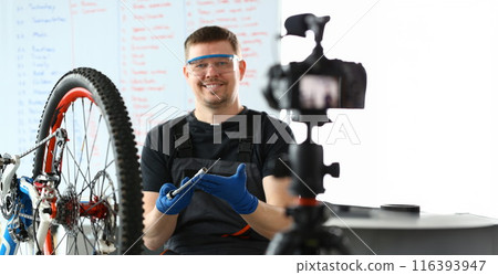 Smiling Man Repairing Mountain Cycle with Spanner 116393947