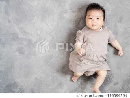 Baby sleeping on the floor on a grey background 116394264