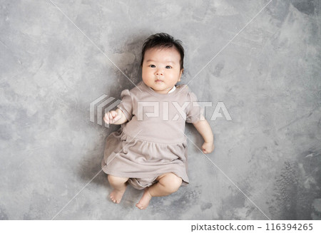 Baby sleeping on the floor on a grey background 116394265