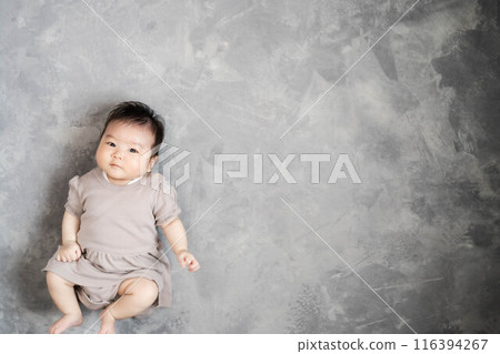Baby sleeping on the floor on a grey background Baby sleeping on the floor on a grey background 116394267