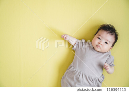 嬰兒躺在黃色的地板上 嬰兒躺在黃色的地板上 116394313