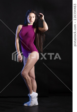 Beautiful young woman in sportswear on a dark background 116394463