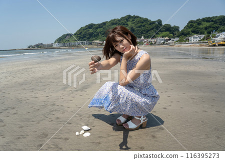 A woman squatting on the beach showing off shells (Yuigahama, Kanagawa Prefecture) A woman squatting on the beach showing off shells (Yuigahama, Kanagawa Prefecture) 116395273