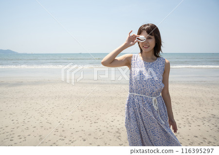 A woman holding a shell on the beach (Yuigahama, Kanagawa Prefecture) A woman holding a shell on the beach (Yuigahama, Kanagawa Prefecture) 116395297