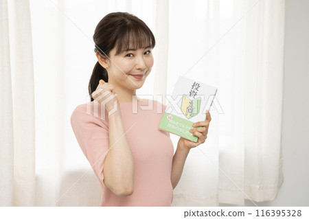 一位女士在閱讀投資書籍時握拳 116395328