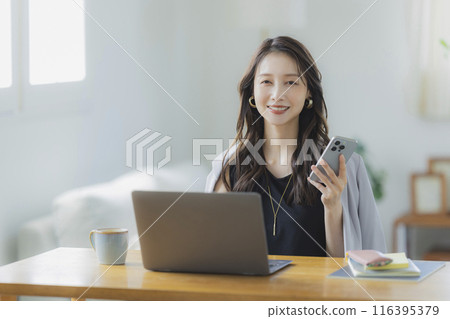 A young woman teleworking in the living room A young woman teleworking in the living room 116395379