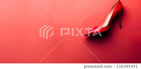 A red high - heeled shoe with a pointed toe, placed against a bright red background with copy space 116395441