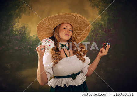 Woman in historical attire, wearing a large straw hat, white blouse, and green skirt, smiling and holding playing cards and stack of poker chips, against vintage background. 116396151