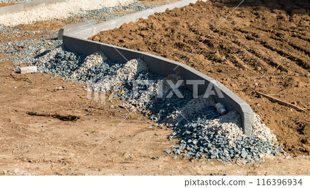 Installing a curb stone in the shape of a circle, bending a pedestrian sidewalk Installing a curb stone in the shape of a circle, bending a pedestrian sidewalk 116396934