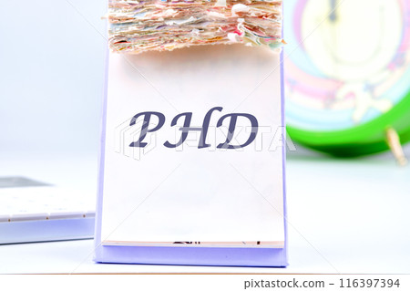 PhD Doctor of Philosophy Degree Education Graduation , PHD text , PHD Knowledge. PHD on a blank sheet of a desktop tear-off calendar 116397394