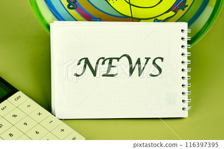 Media concept. Text NEWS a note written on a blank sheet of a notebook in a composition with a fragment of a calculator, an alarm clock on a green background 116397395