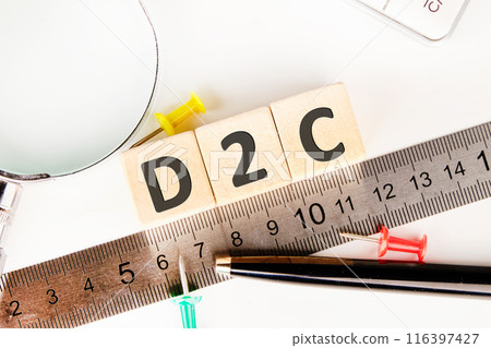 D2C word concept written on wooden cubes laid out along the measuring ruler 116397427