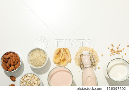Bottle and glass with alternative milk and herbal ingredients on white background, space for text Bottle and glass with alternative milk and herbal ingredients on white background, space for text 116397802