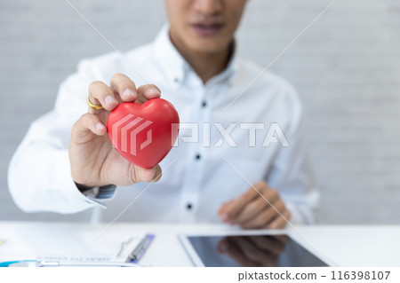 Doctor hands hold a red heart over desk. Concept of health care and medical. Doctor hands hold a red heart over desk. Concept of health care and medical. 116398107