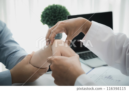 Orthopaedic doctor doing physical examination patient with wrist pain at the clinic. Physical therapist checks the patient wrist by pressing the wrist bone. Orthopaedic doctor doing physical examination patient with wrist pain at the clinic. Physical therapist checks the patient wrist by pressing the wrist bone. 116398115