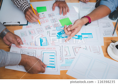 UX or UI designers designing on their smartphone application layout prototype project. UX or UI designers designing on their smartphone application layout prototype project. 116398235