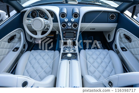 The picture presents a pristine white luxury car interior, with a detailed dashboard and quilted leather seats, reflecting a blend of elegance and advanced design. 116398717
