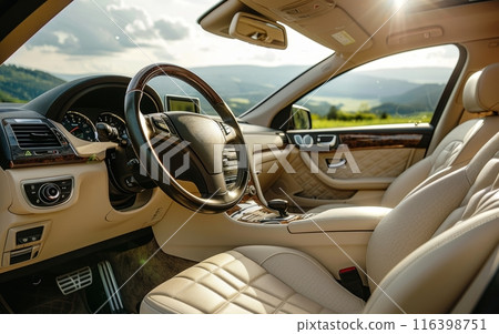 Sunlight streams into the car, illuminating the plush beige leather interior with a panoramic view of the rolling hills, offering a serene drive in a luxuriously appointed cabin. 116398751
