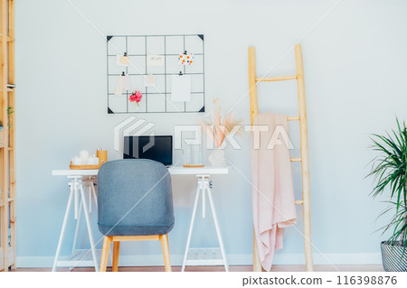 Home office workplace design. White desk with open laptop mockup, grid mood board with peach and pink colors palette and cozy feminine decor, like candles, dried flowers. Inspiration and mood concept. 116398876