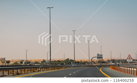 Fujairah mountains, extension of Omani Al Hajar mountain range. Cloudy winter day on empty street. High quality photo 116400258
