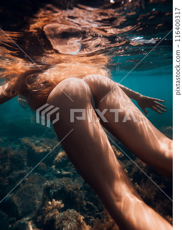 Ideal body of slim woman with red hairs underwater in blue sea 116400317