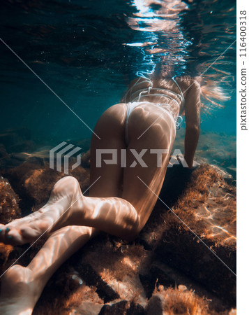 Perfect body of sporty slim woman underwater in sea Perfect body of sporty slim woman underwater in sea 116400318